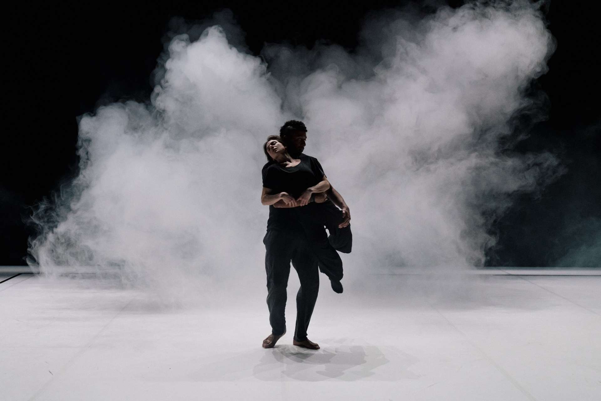 Deux interprètes arrivent face à nous. Derrière eux, un nuage de fumée blanche. 